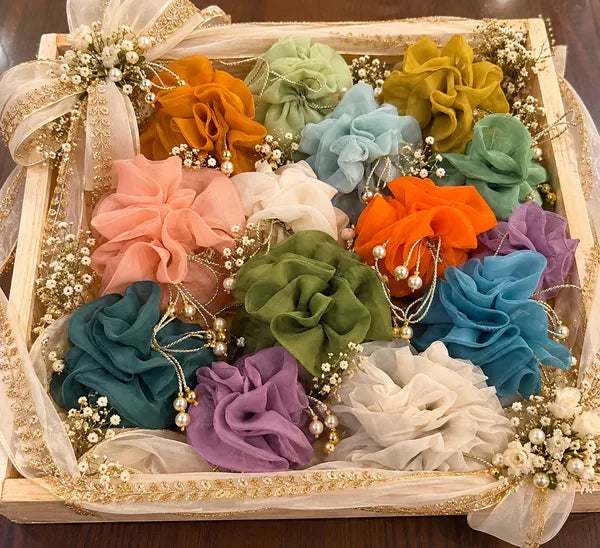 Wooden tray of mixed colour wedding favour potlis