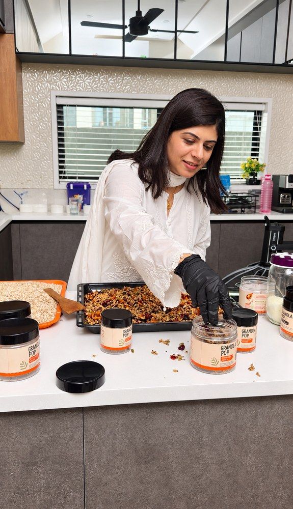 Fatima in the kitchen, filling jars of granola