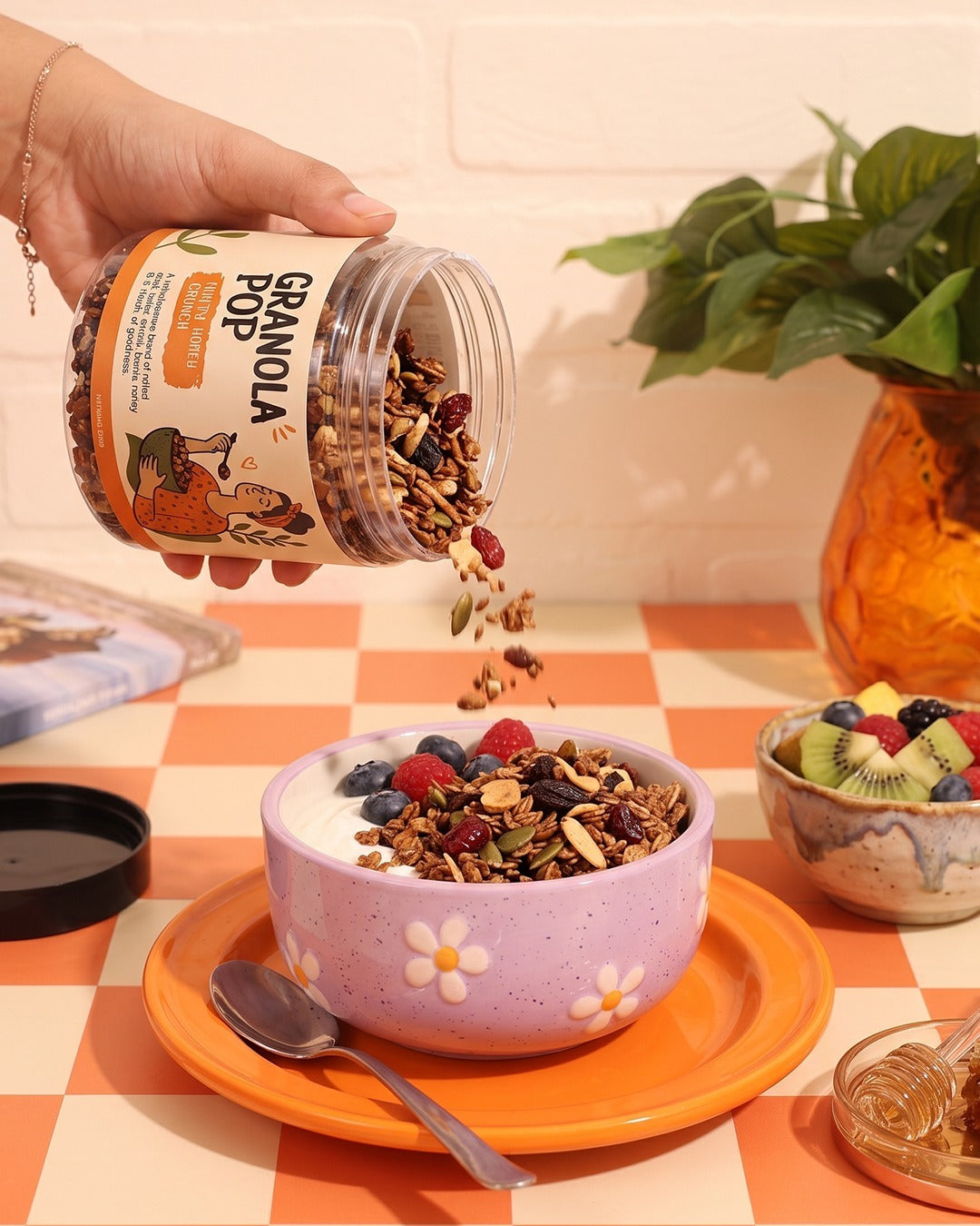 Granola Pop poured over a bowl of yogurt and fresh fruit